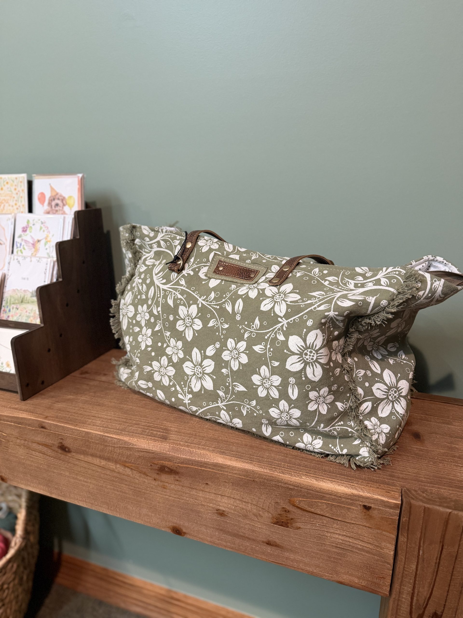 Sage green floral print canvas tote with frayed fringe edges