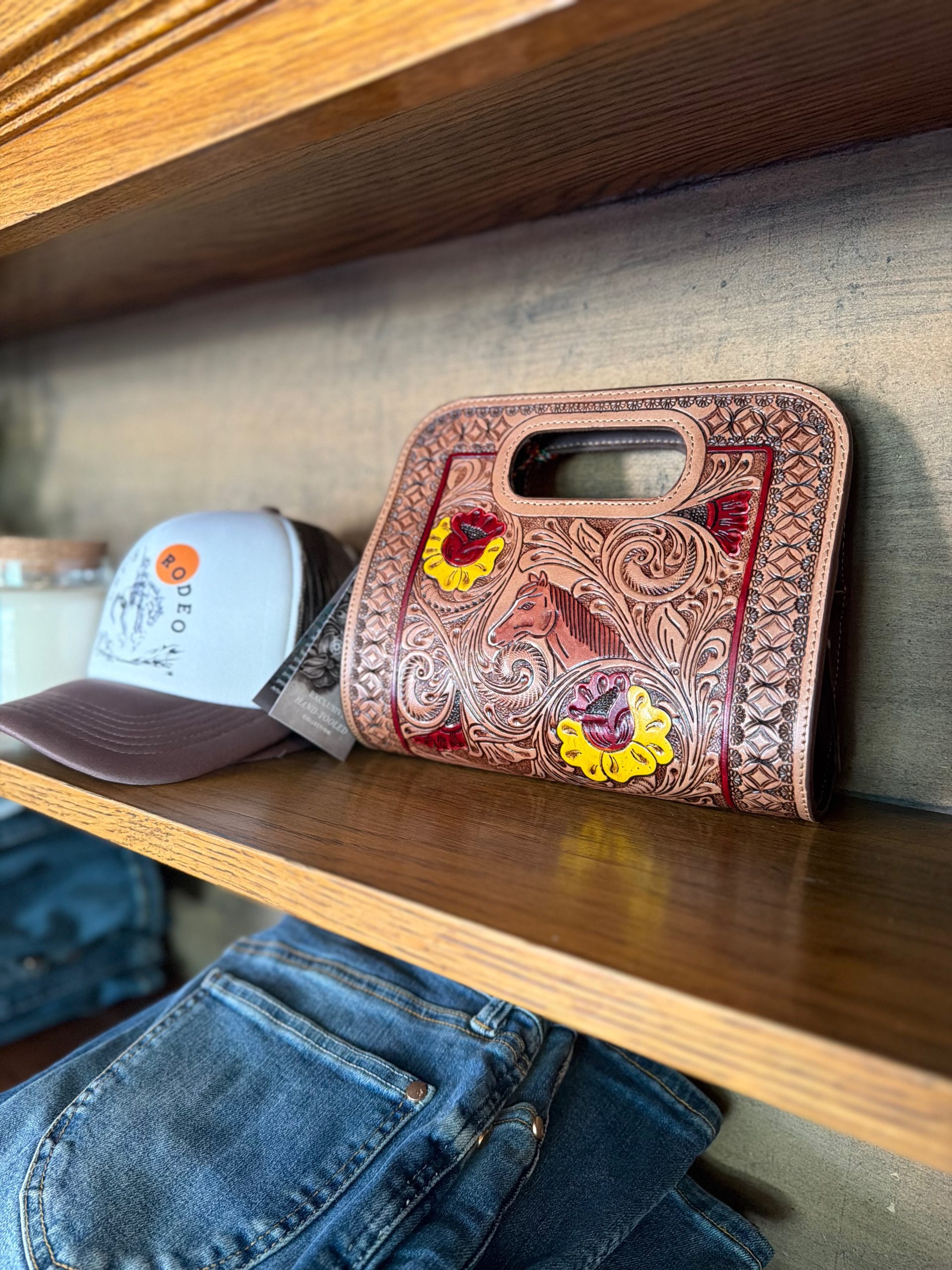 Hand-tooled leather clutch with horse design and floral accents