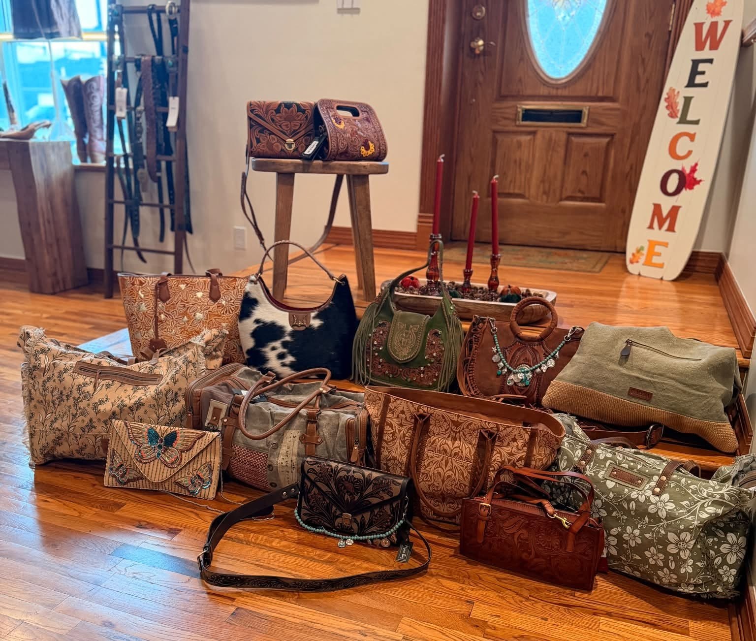 Many one-of-a-kind leather, woven and printed bags and purses arranged on the floor of the boutique